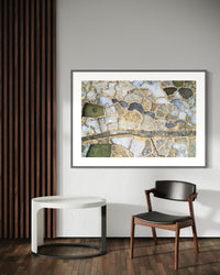 Salt Pans of Gozo, Malta, framed above a desk with a reading lamp