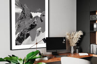 Tantalus 4 print framed above a desk with a monitor and plants