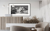 Icons of the Valais Alps panorama framed above a sofa on a slatted wood wall