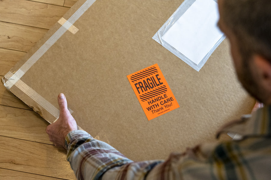 A crated print marked fragile being readied for white glove delivery