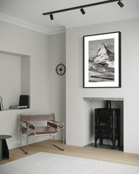 Matterhorn and the Gornergrat print framed in a white room with a wood stove