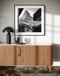 Zermatt Village print framed above a wooden sideboard